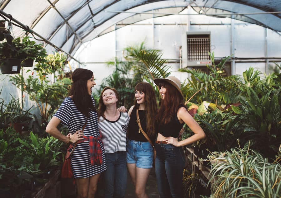 a group of women standing in a greenhouse