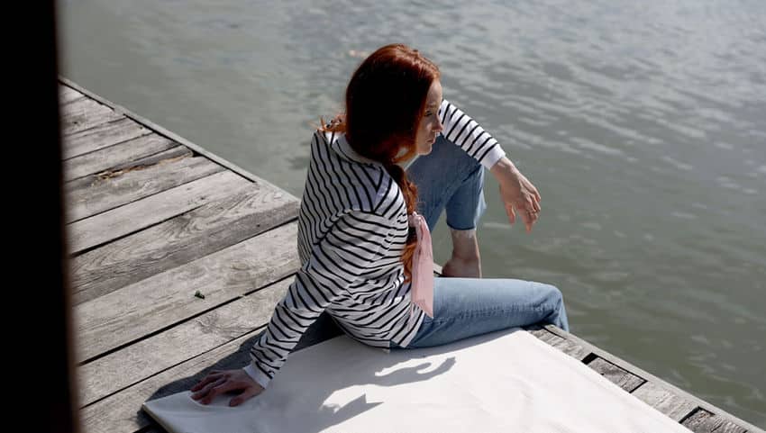 a woman sitting on a dock