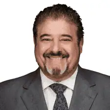 Professional man in a suit smiling for a corporate portrait.