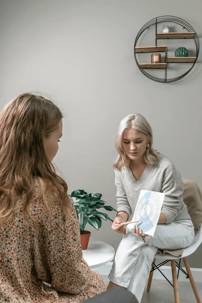 Two women in a consultation room discussing health and wellness.