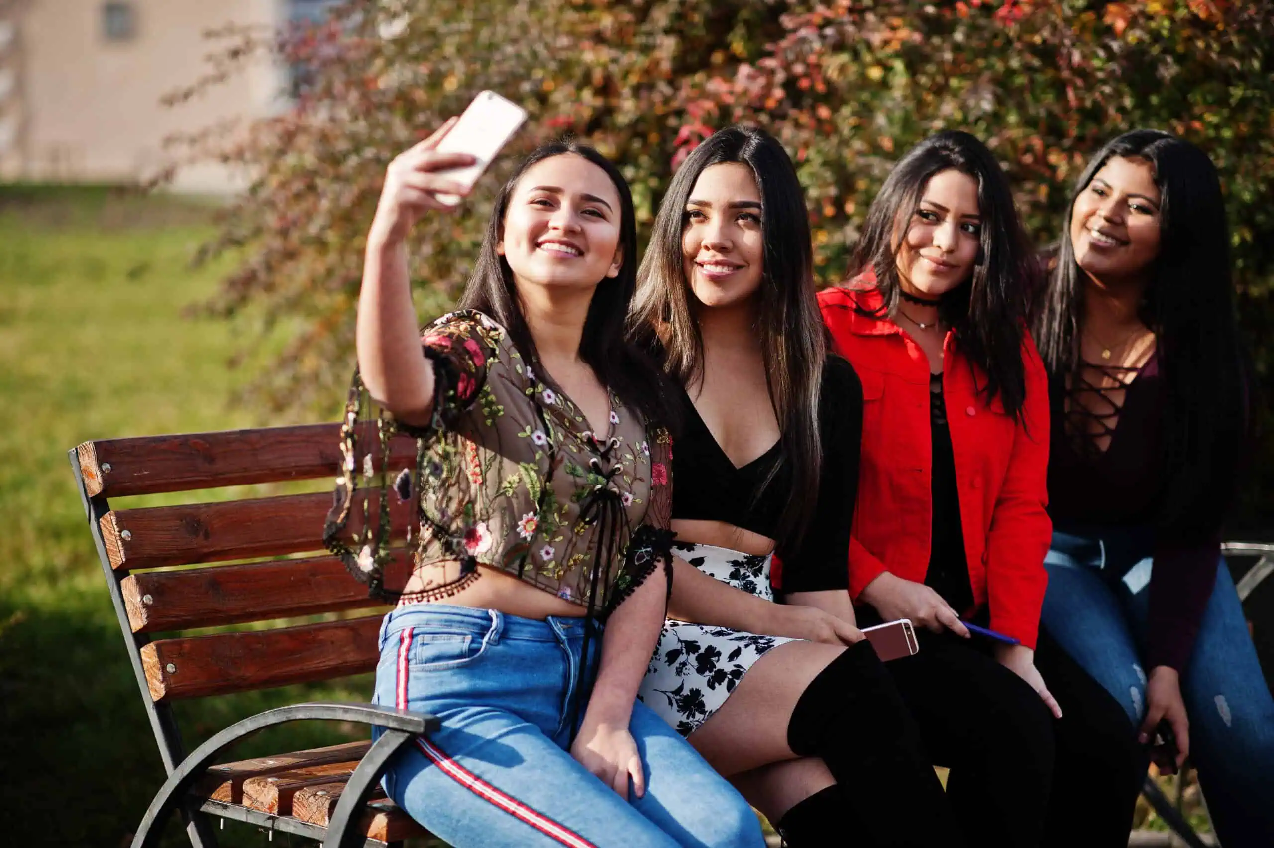 Young Latina college woman smiling outdoors near Riverside