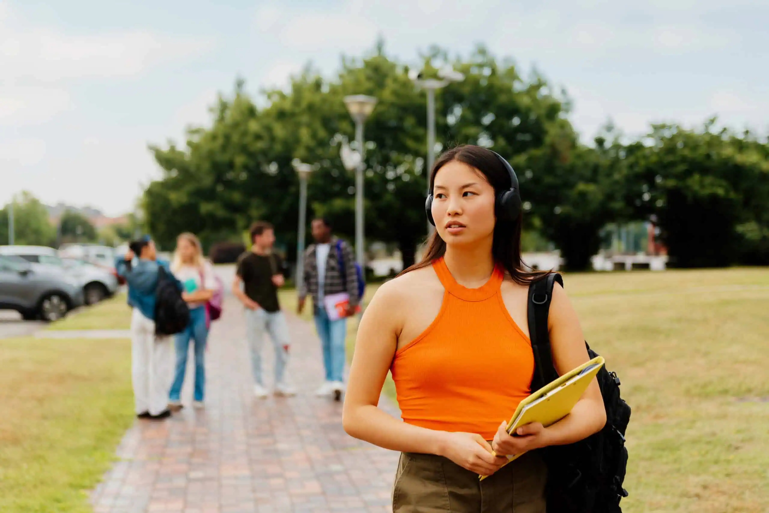 A woman looking stressed on campus for the topic signs a college student needs more than weekly therapy.