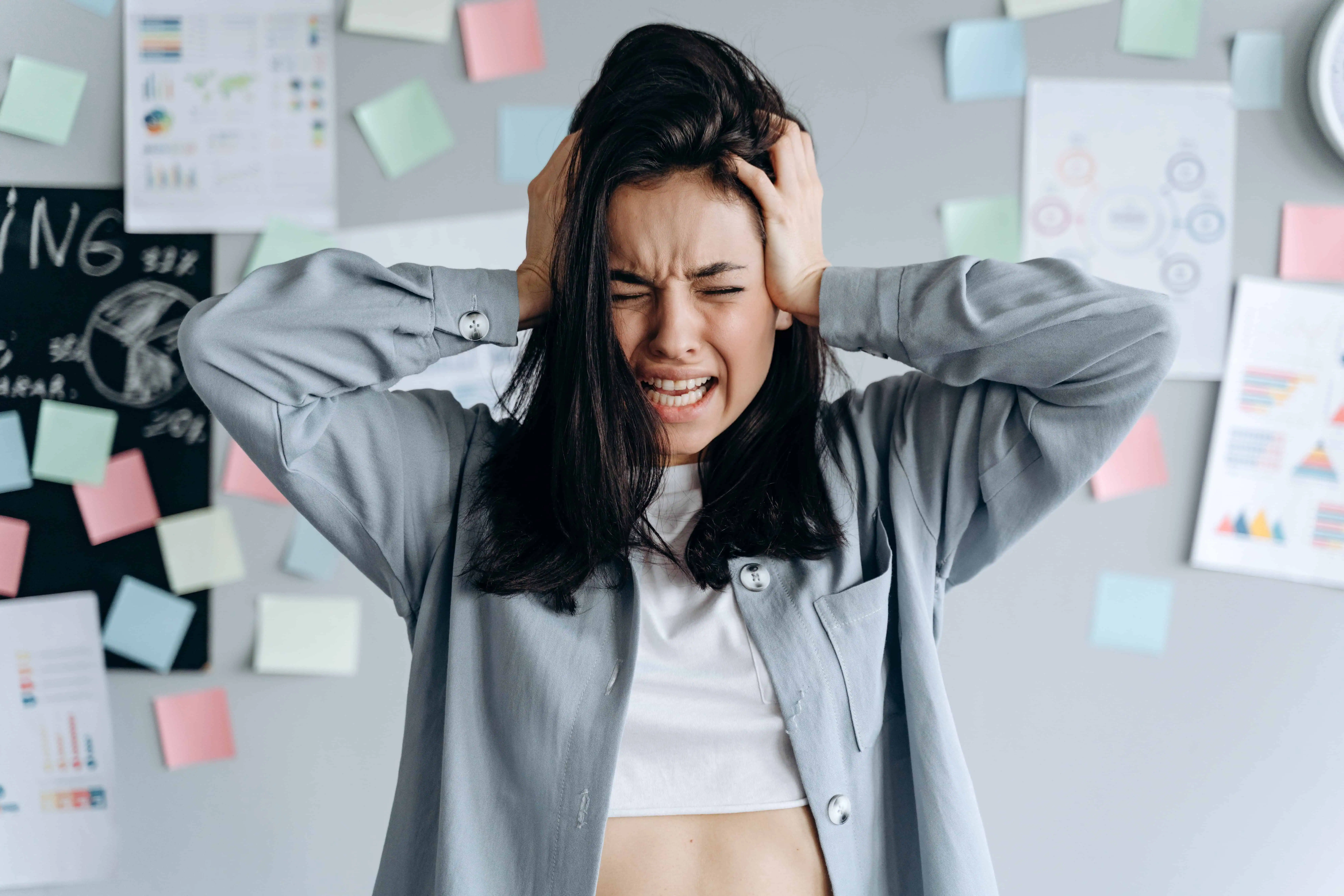 Frustrated woman holding her head in stress at work.