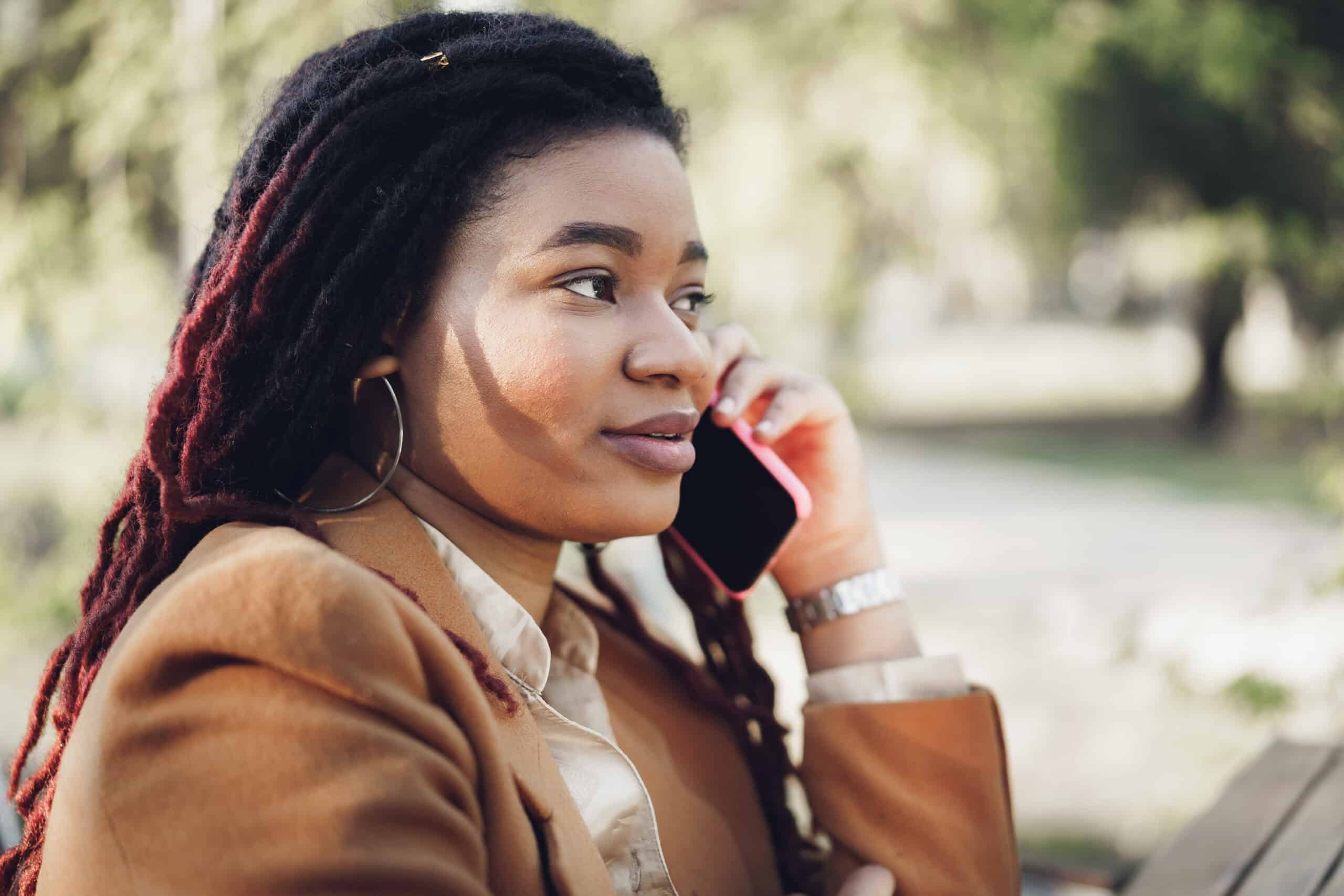 A woman speaking calmly on the phone as she reaches out for mental health support